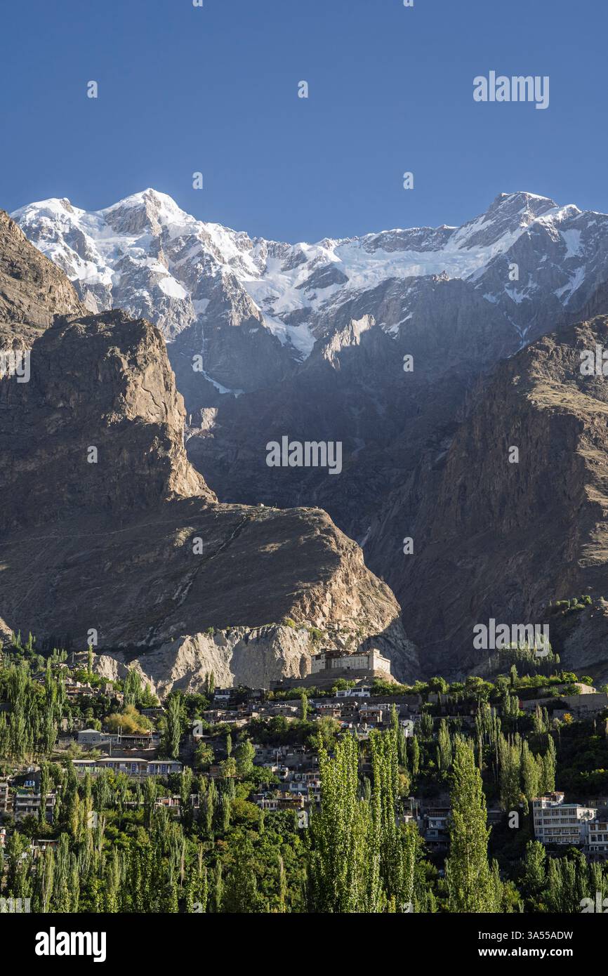 Vista panoramica verticale mattutina della città di Karimabad con lo storico forte Baltit e lo sfondo montano di Ultar sar, Hunza, Gilgit-Baltistan, Pakistan Foto Stock