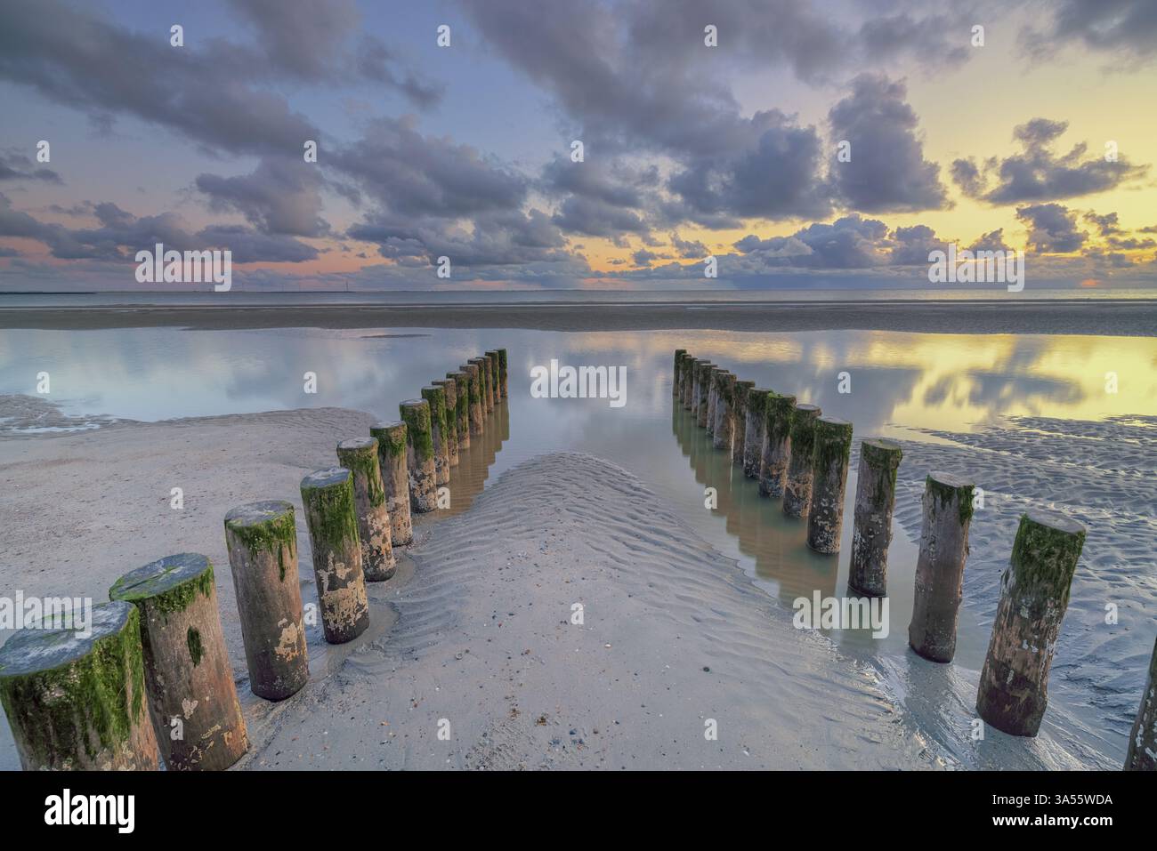 Tramonto sulla spiaggia della Zelanda, Paesi Bassi, con un bel cielo e strutture nella sabbia Foto Stock Tramonto sulla spiaggia della Zelanda, Paesi Bassi, con un bel cielo e strutture nella sabbia Foto Stock