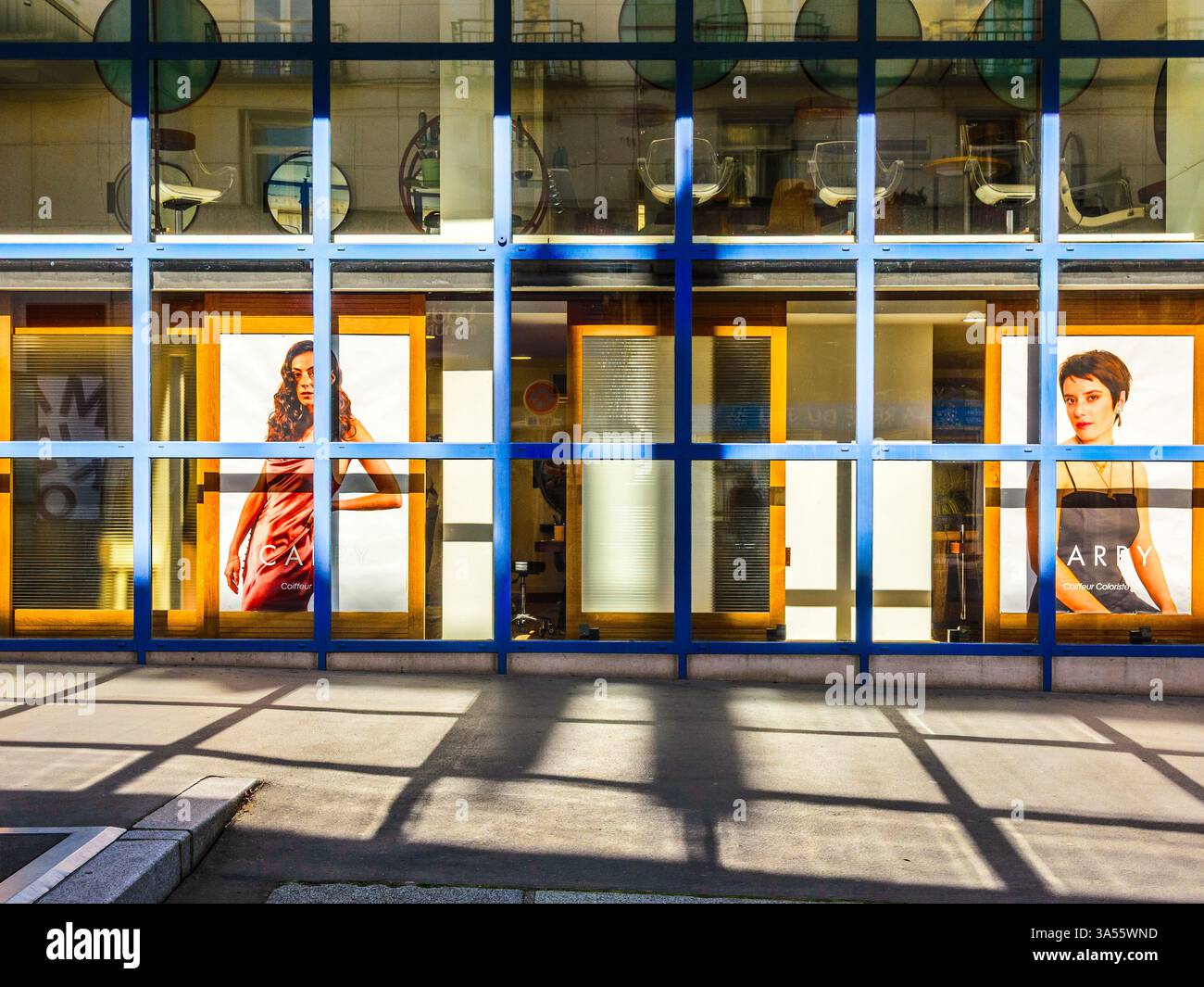 Moderne finestre di salone di bellezza con riflessi di luce e ombre gettate sulla strada - Tours, Indre-et-Loire (37), Francia. Foto Stock
