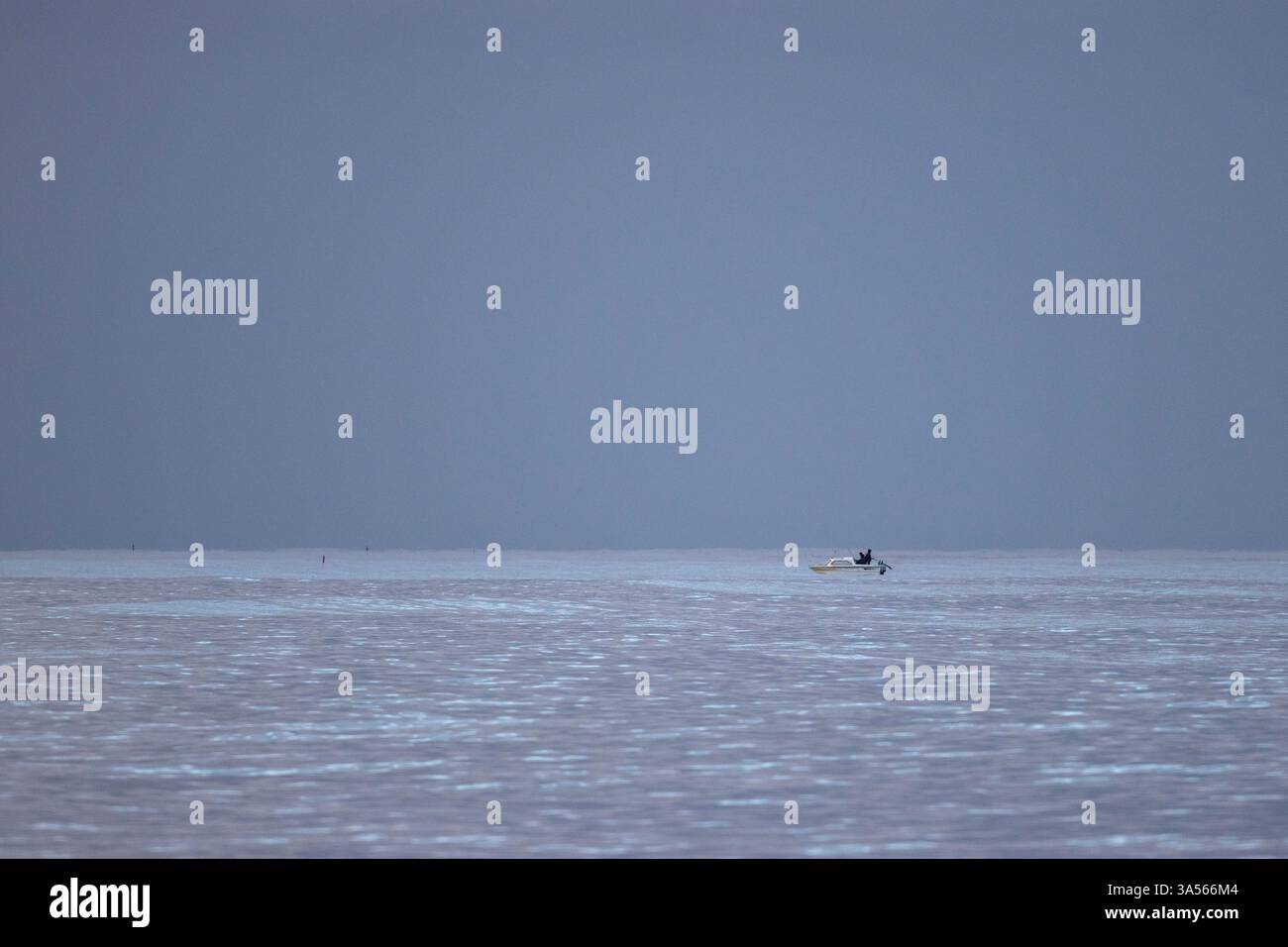 Piccolo peschereccio ancorato nel Mare del Nord al largo della costa orientale del Lothian al crepuscolo, Scozia, Regno Unito Foto Stock