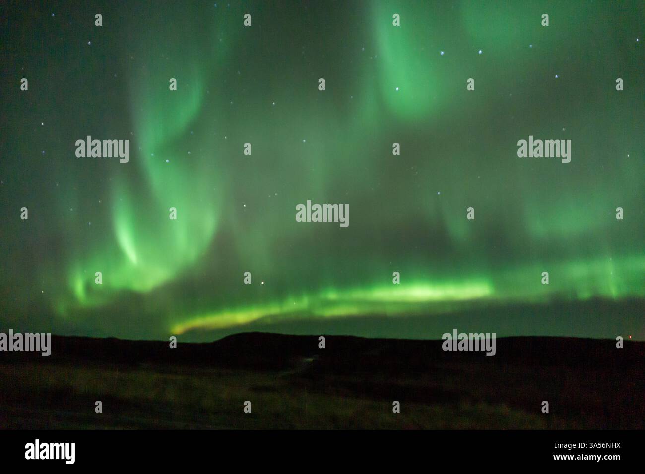 Spettacolare aurora boreale sul paesaggio invernale dell'Islanda con la vibrante Aurora boreale verde e viola nel cielo notturno Foto Stock