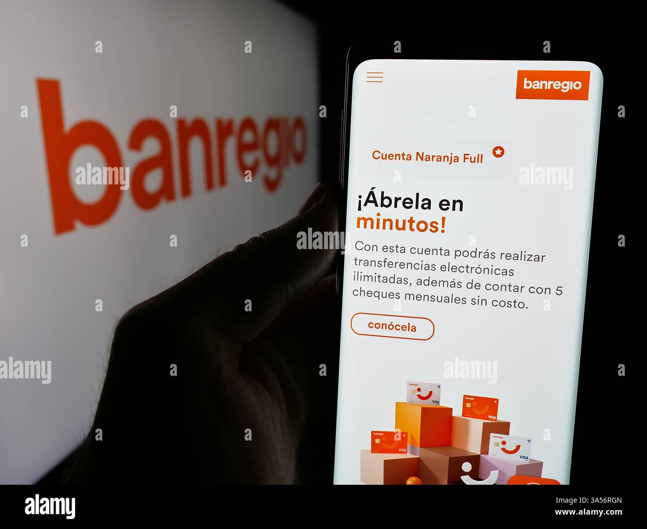 Stoccarda, Germania - 11-11-2024: Persona che detiene il cellulare con pagina web della società Banregio Grupo Financiero S.A.B. de C.V. su schermo con logo. Foto Stock