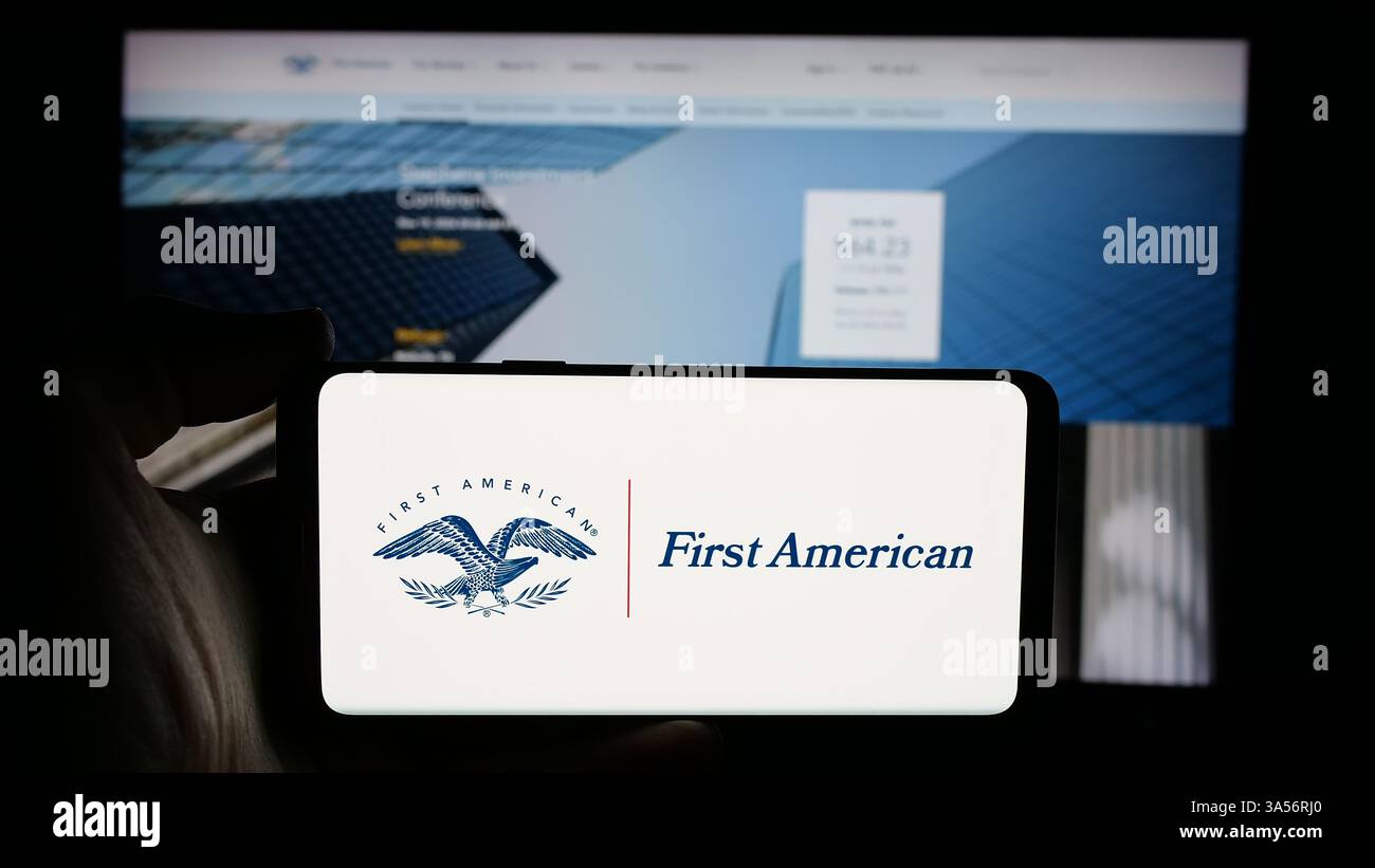 Stoccarda, Germania - 11-11-2024: Persona che detiene il cellulare con il logo della società statunitense First American Financial Corporation sullo schermo Foto Stock