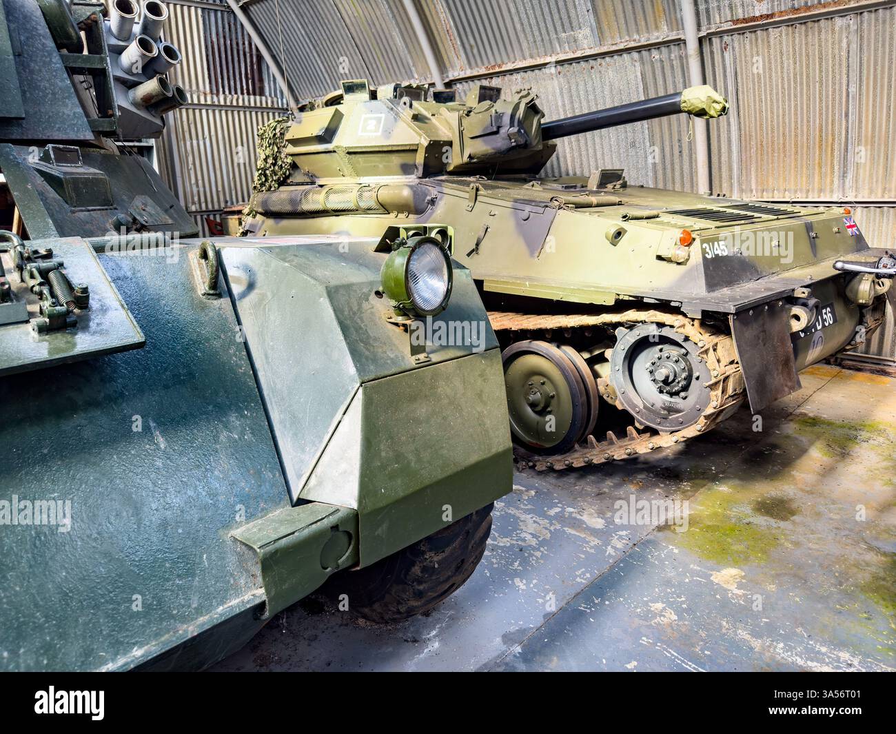 Veicoli corazzati militari britannici, tra cui un carro armato FV101 Scorpion all'interno di un hangar esposto al NELSAM North East Land Sea & Air Museum - Immagine stock catturata con smartphone