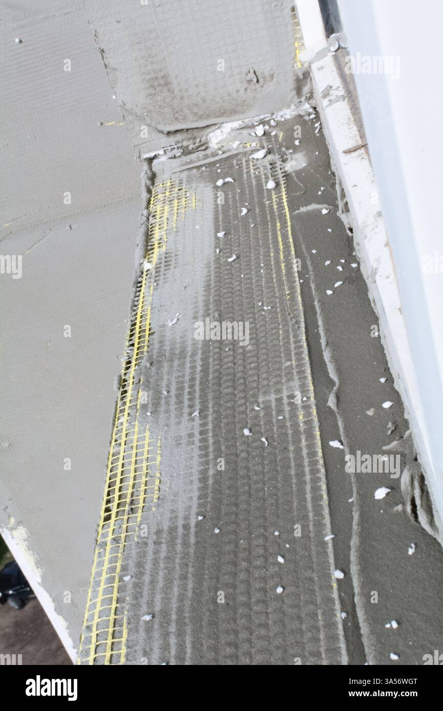 Rete per facciate ricoperta di intonaco. Isolamento della facciata di un condominio. Preparazione della facciata per l'isolamento con plastica espansa. Selez Foto Stock