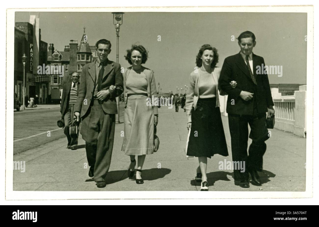 Foto originale tipica degli anni '1940 del dopoguerra scattata dai fotografi di mare, Walfred di Skegness, di due coppie che passeggiano in vacanza, vestiti in modo elegante, godendosi una rilassante passeggiata insieme lungo la Grand Parade - buoni dettagli di moda / acconciatura. Belle signore. Datata 1949 al contrario. Skegness, Lincolnshire, Inghilterra, Regno Unito Foto Stock
