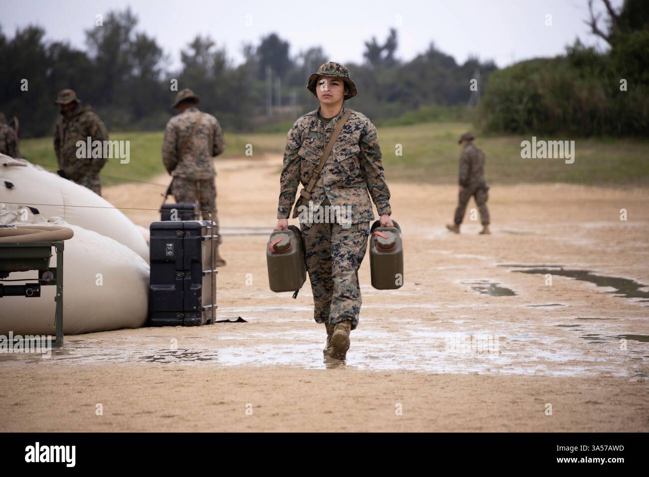 Breana Martinez, elettricista del 9th Engineer Support Battalion, 3rd Marine Logistics Group, trasporta lattine di combustibile durante un'operazione di supporto all'acqua a Kin Blue, Okinawa, Giappone, 17 marzo 2025. I marines con 9th ESB hanno condotto operazioni di supporto idrico come parte di un esercizio di addestramento sul campo di 10 giorni per sostenere i compiti essenziali della missione e affinare i piani in preparazione di Resolute Dragon 25. Martinez è nativo del Texas. (Foto del corpo dei Marines degli Stati Uniti di Lance Cpl. Marcus Henson) Foto Stock