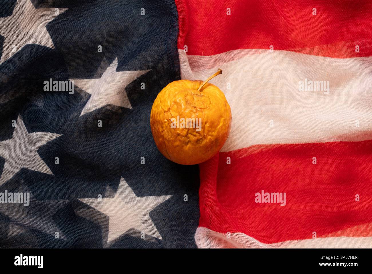 La mela marcio e secca giace sulla bandiera americana, sulla crisi e sui problemi Foto Stock