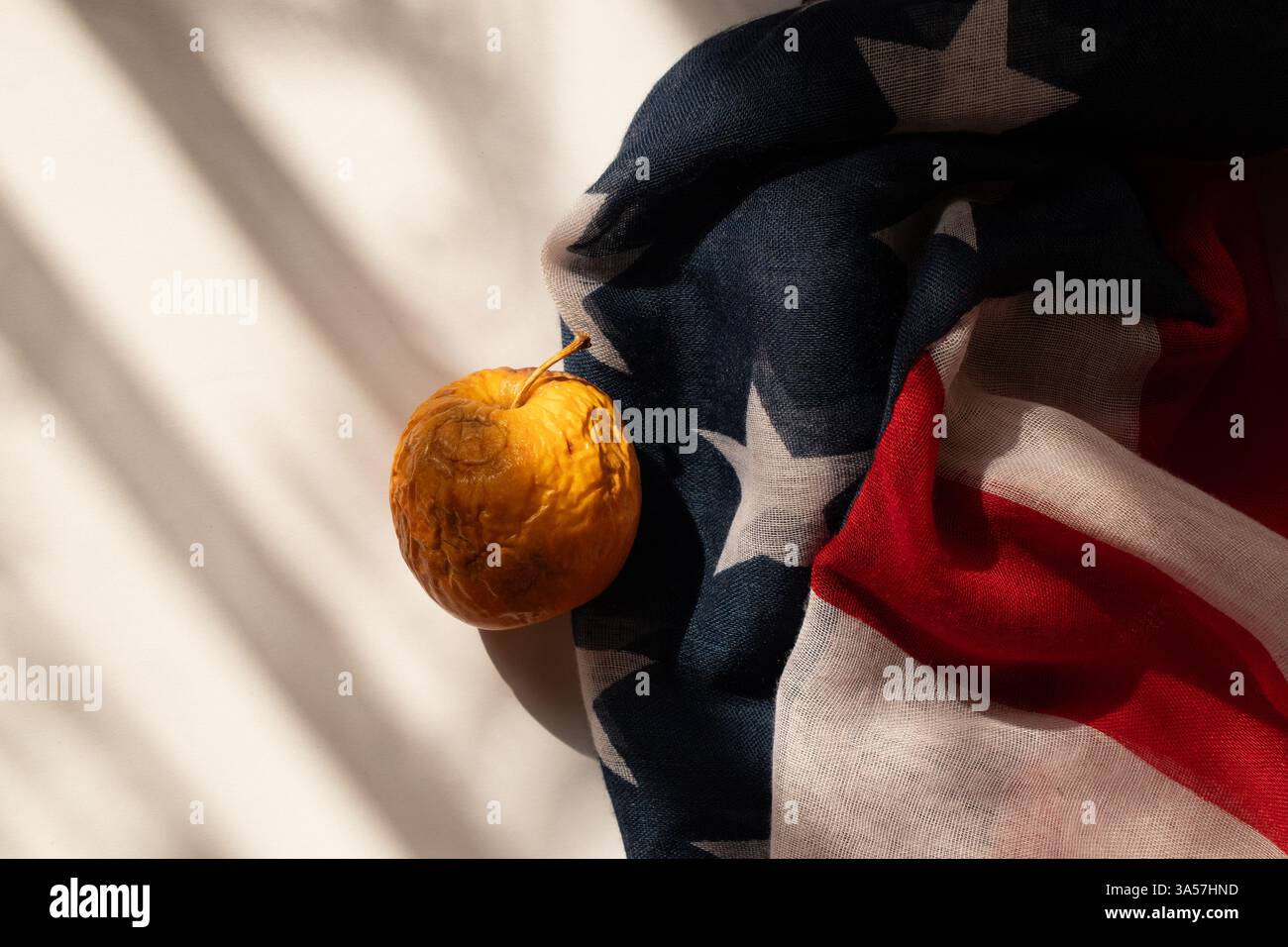 La mela marcio e secca giace sulla bandiera americana, sulla crisi e sui problemi Foto Stock