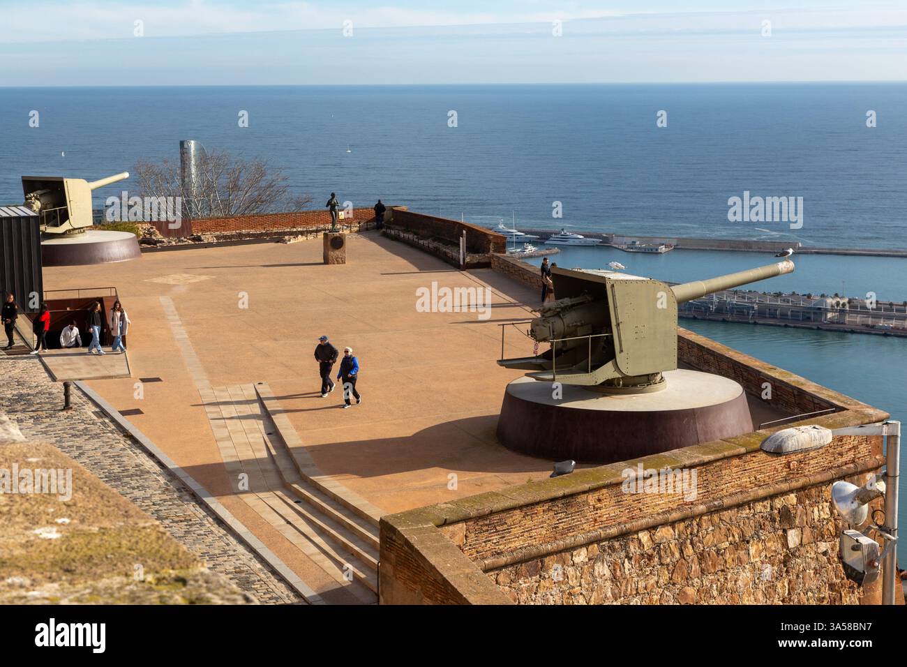 Turisti che camminano sul tetto del castello o del castello di Montjuic. Vecchia fortezza difensiva catalana del Mediterraneo cannoni militari, Barcellona Spagna Foto Stock