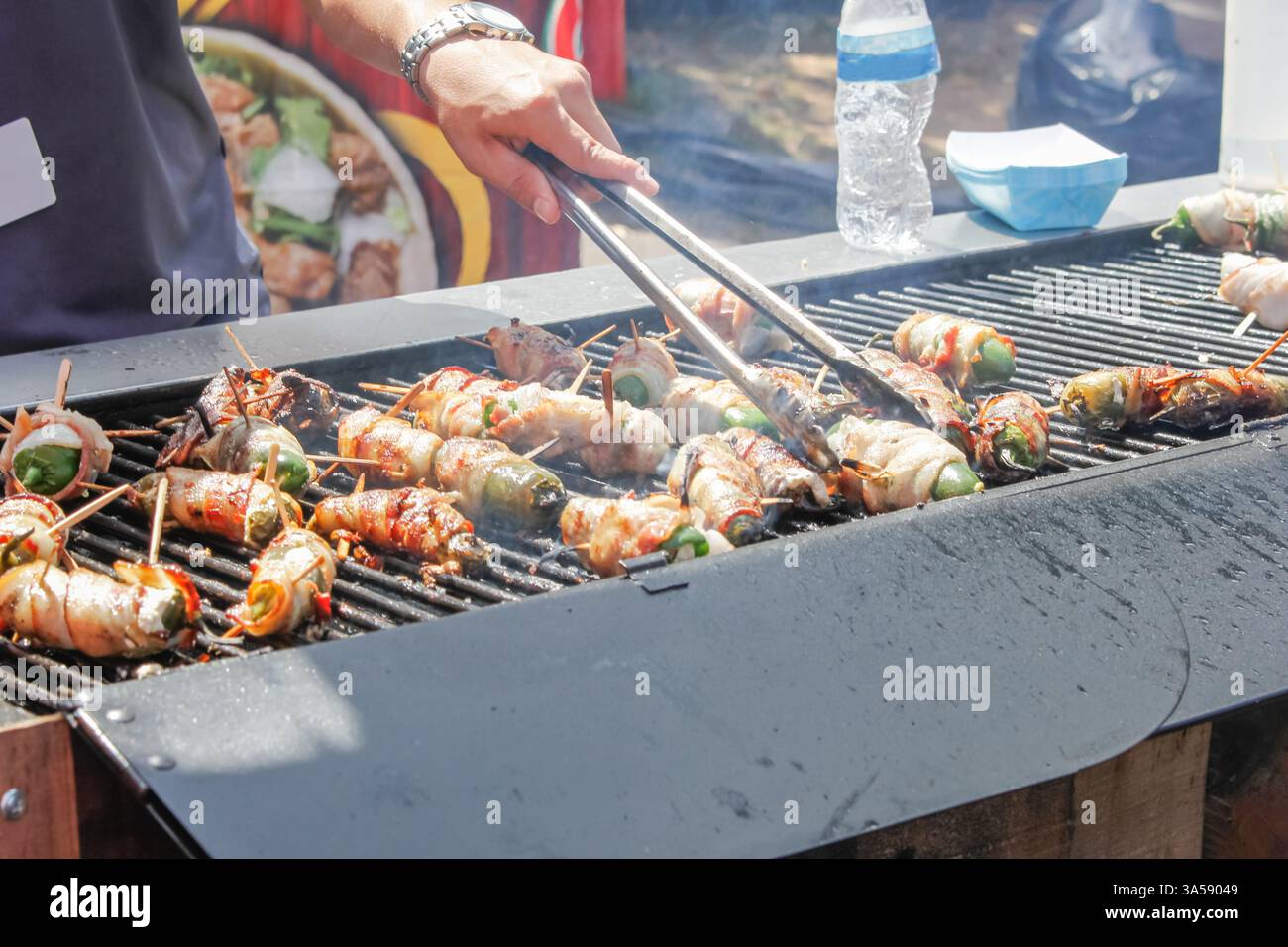 Una vista di un pop jalapeno avvolto con bacon da cucina sulla griglia. Foto Stock