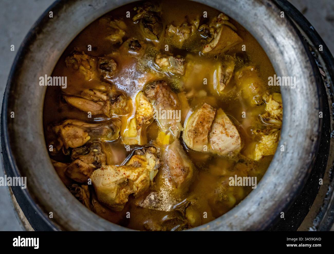 Stufato di pollo bollito in una pentola, cucinato all'aperto su un falò, Uttarakhand, India, ricetta sana. Foto Stock