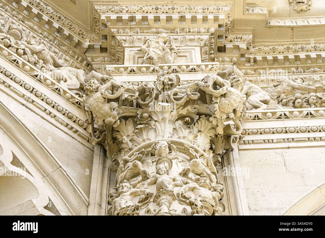 Primo piano di intricate decorazioni in pietra su una capitale architettonica a colonne nella Cattedrale di Siviglia. Foto Stock