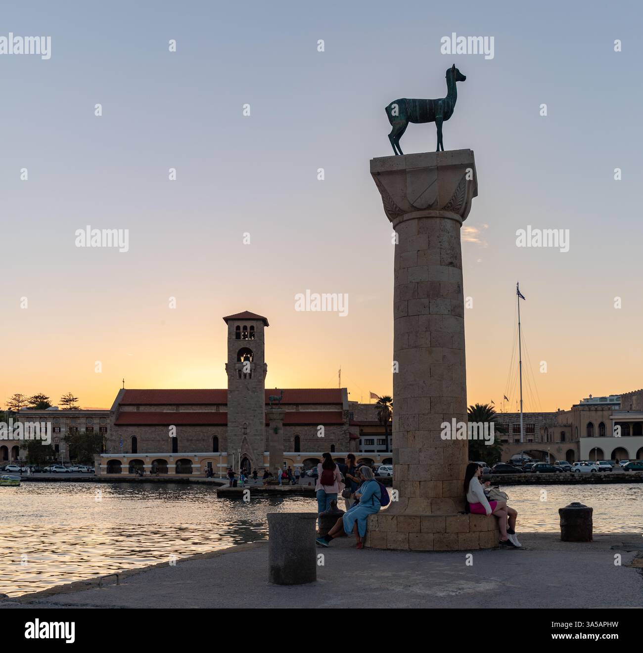 Una foto della Chiesa dell'Annunciazione della Theotokos e del Colossus di Rodi - Statua di Doe al tramonto. Foto Stock