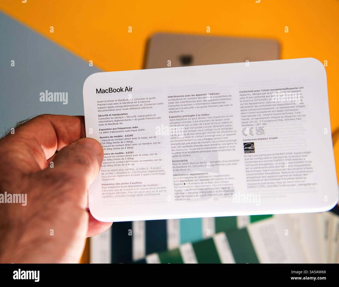 Parigi, Francia - 13 marzo 2025: Documento informativo disponibile su display portatili, sicurezza multilingue, conformità e specifiche del modello per MacBook Air PL Foto Stock