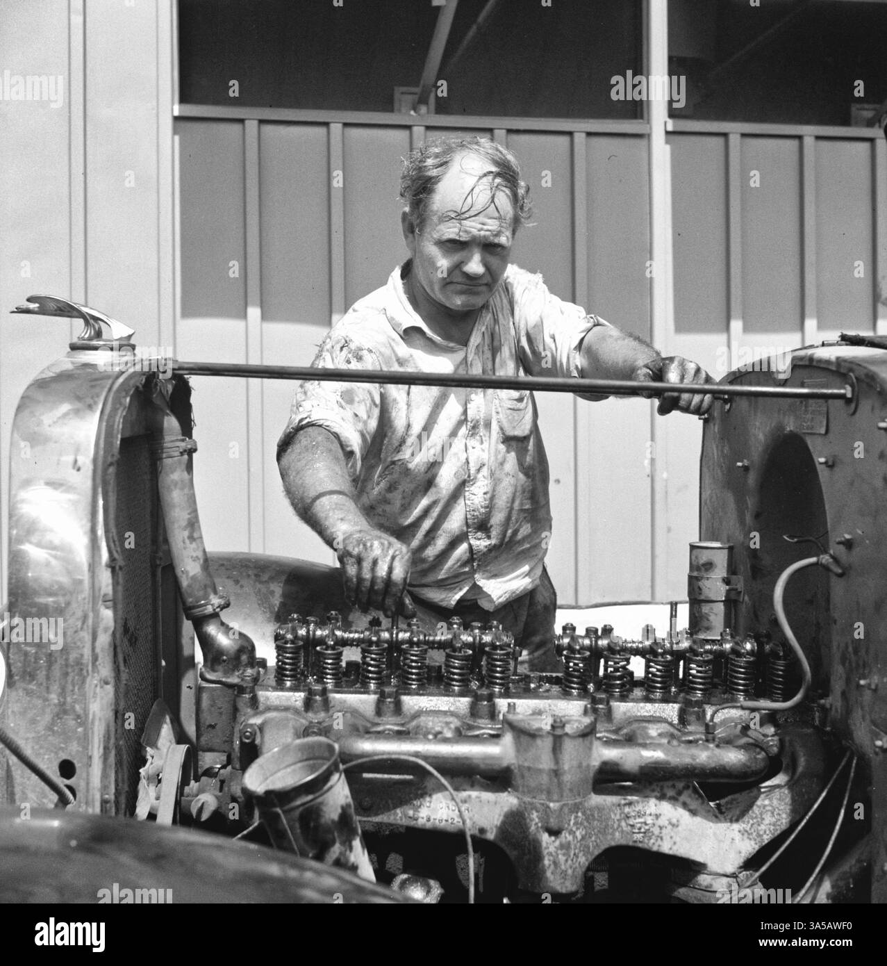 Membro del campo che ripara la sua auto fuori dal suo rifugio. Campo di lavoro migratorio di Osceola. Belle Glade, Florida, 1940 Foto Stock