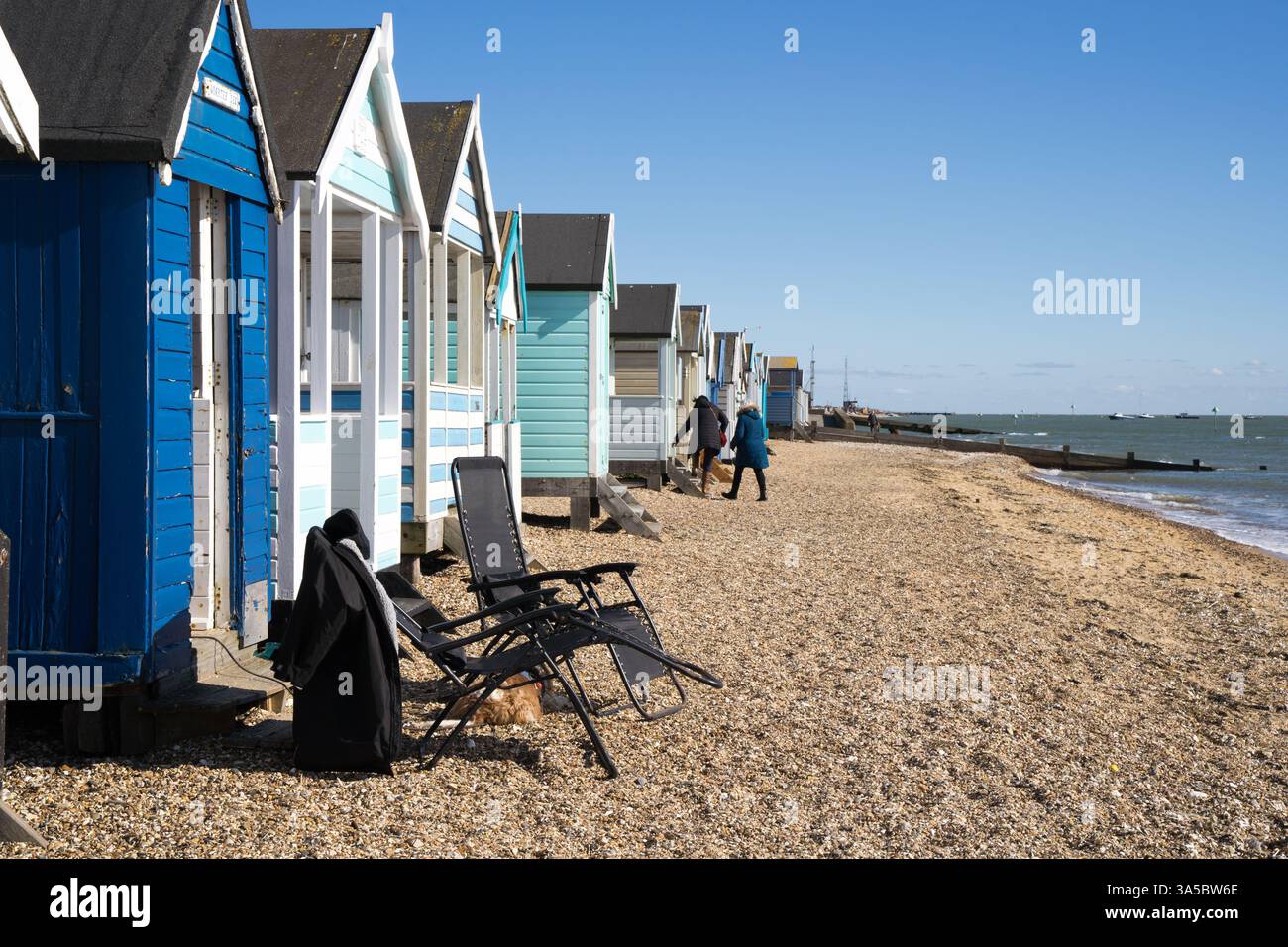 Il proprietario della spiaggia è andato a trovare i loro vicini con sedie a sdraio lasciate davanti alle capanne sulla spiaggia, Southend-on-Sea, Essex Inghilterra, Regno Unito Foto Stock