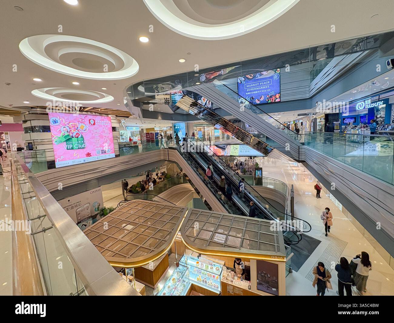 Vista dell'interno multilivello di un centro commerciale con scale mobili e negozi nell'area di Tseung Kwan o di Hong Kong. Foto Stock