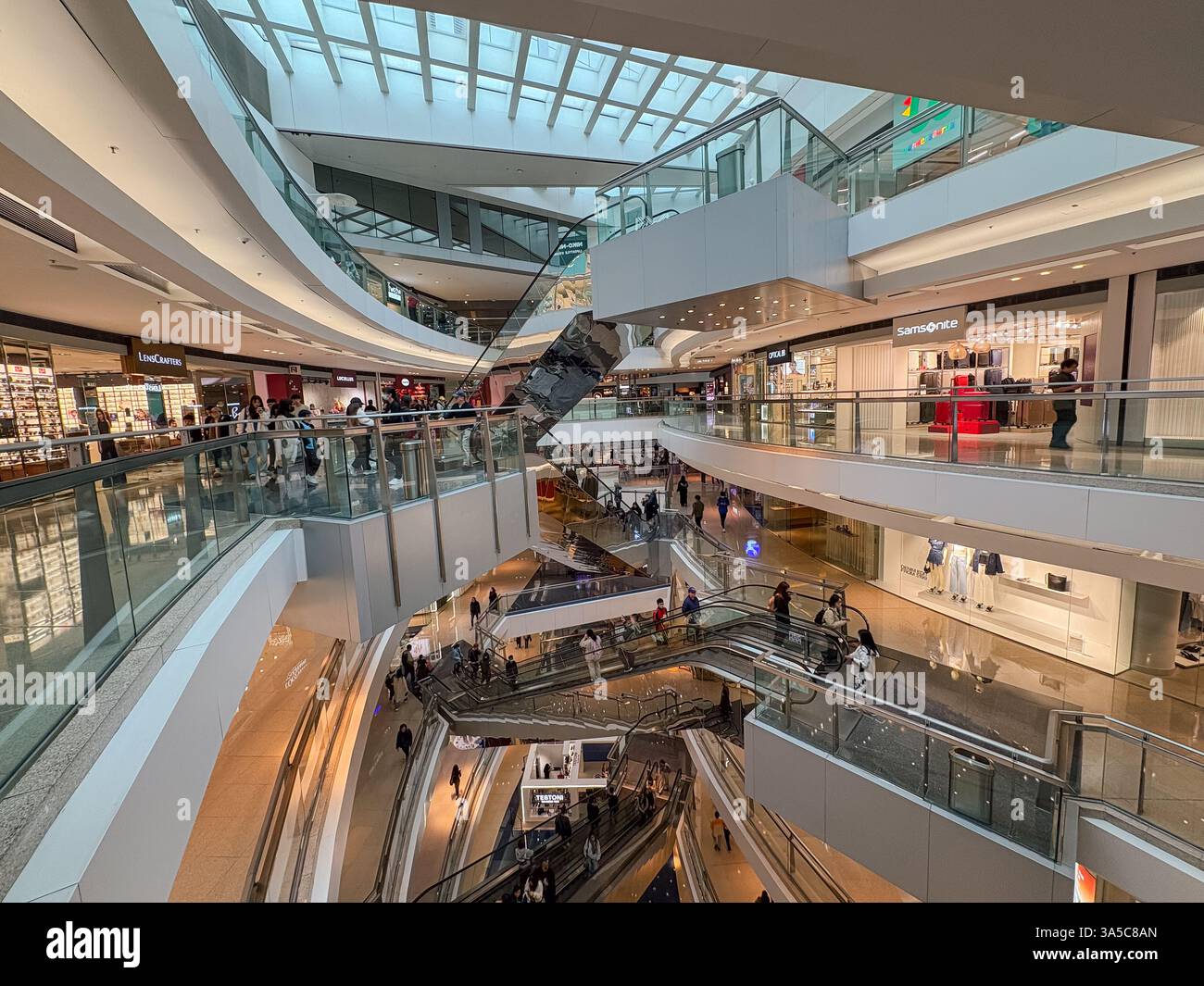 Vista interna di un centro commerciale a più piani di Hong Kong con persone, scale mobili e negozi. Foto Stock Vista interna di un centro commerciale a più piani di Hong Kong con persone, scale mobili e negozi. Foto Stock