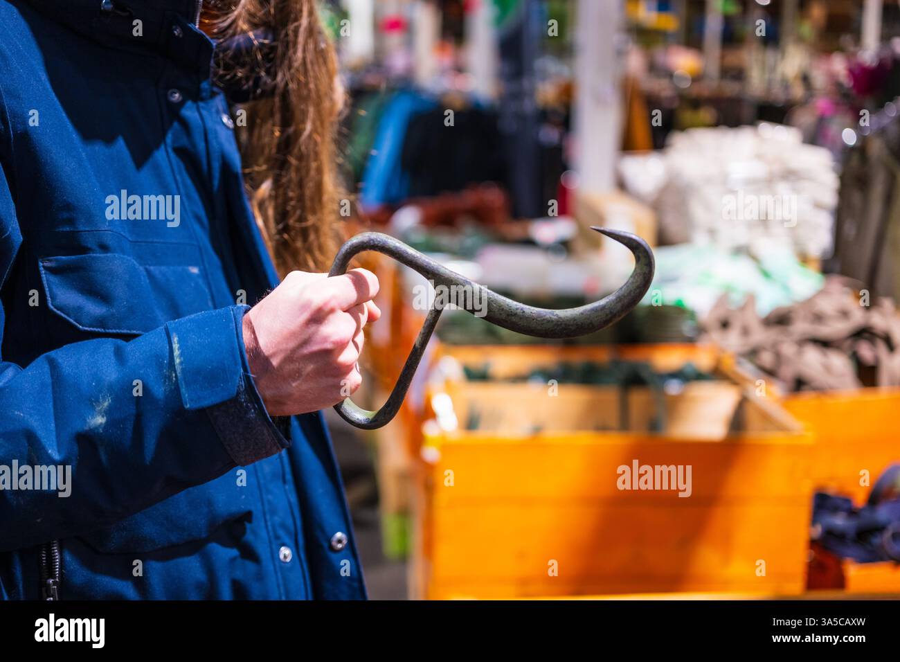 persona che tiene un tradizionale gancio per carne in metallo Foto Stock