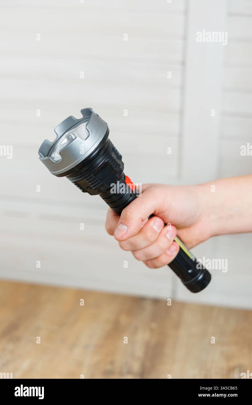Una persona ha in mano una potente torcia che è perfetta per le emergenze e le avventure all'aperto Foto Stock