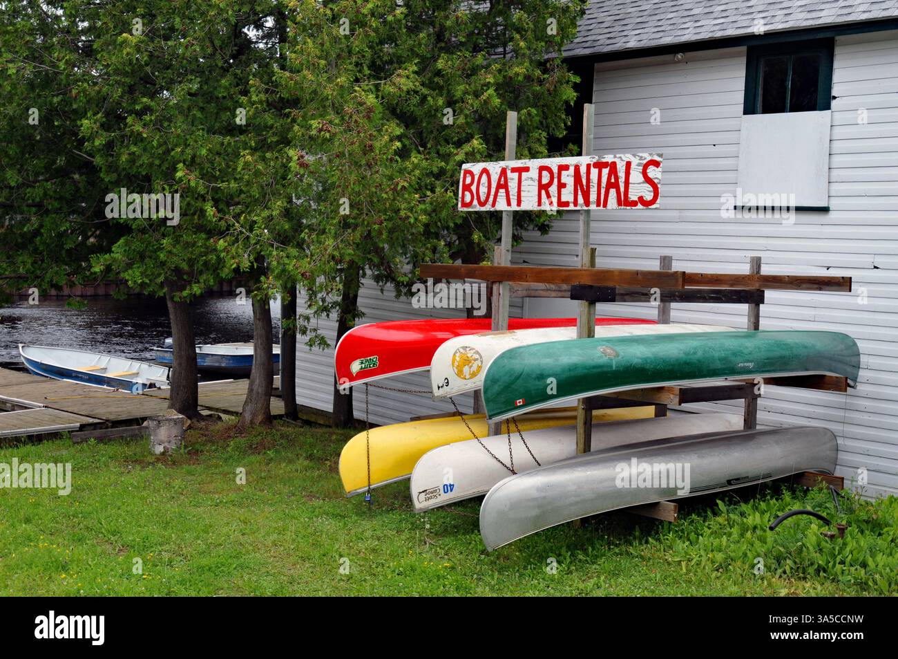 Le canoe si trovano all'esterno di un'azienda di noleggio barche nella comunità di Bala, Ontario cottage country. Foto Stock