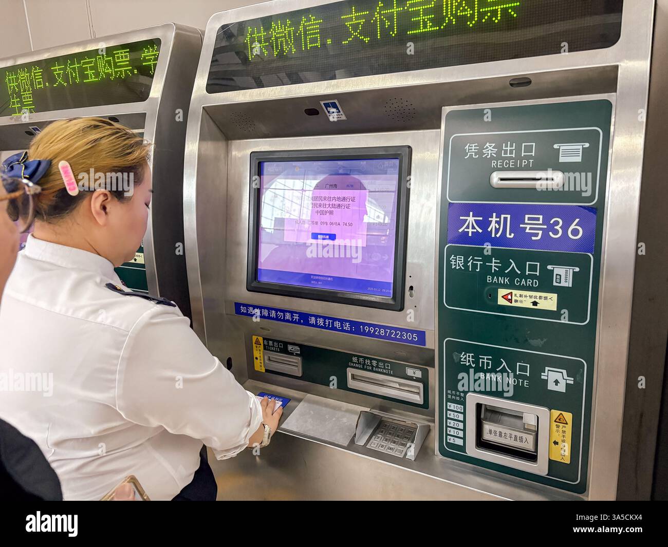 Primo piano di un distributore automatico di biglietti self-service in Cina, che mostra lo slot per ricevute, i lettori di carte e banconote e una donna che lo utilizza. Foto Stock