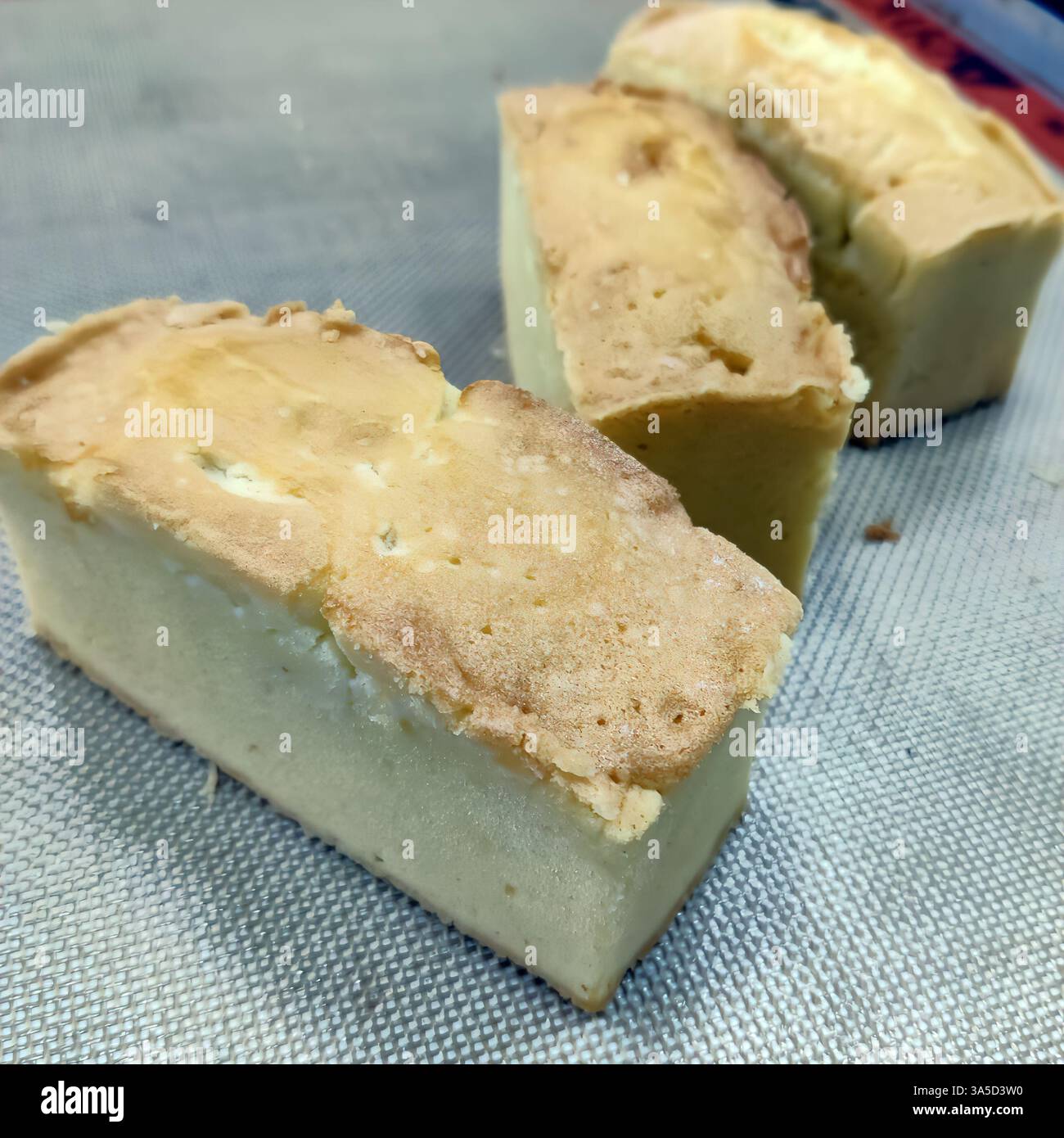 Fette morbide e umide di torta da libbra sono disposte ordinatamente accanto a una torta intera, mostrandone la consistenza e il colore nella panetteria. Foto Stock