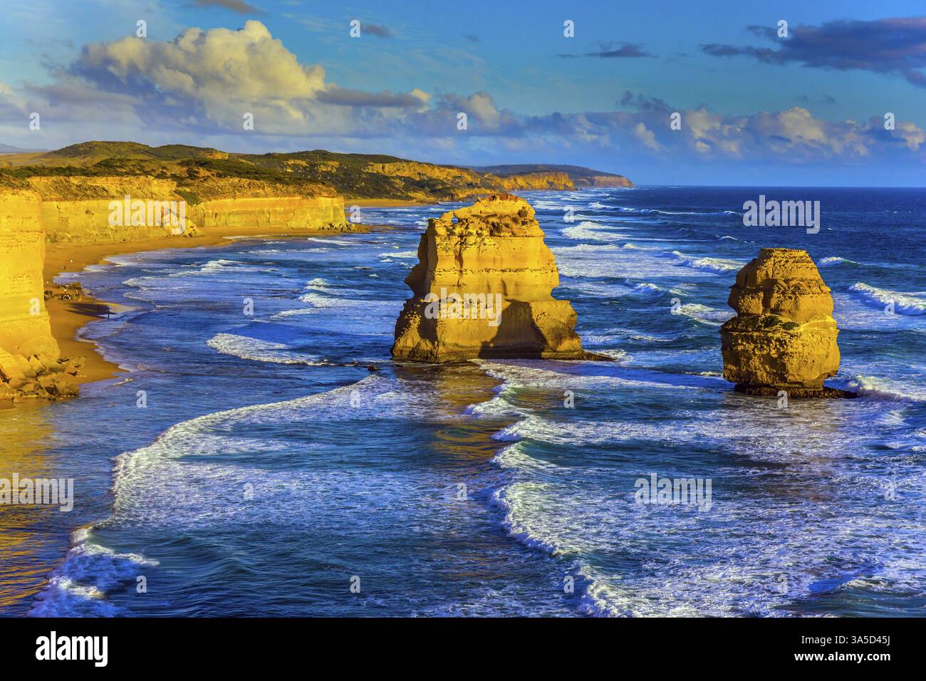 Potente surf sull'oceano e rocce dei dodici Apostoli al tramonto. Grandiosa costa dell'Australia. Il concetto di esotico, attivo e fotoritocco Foto Stock