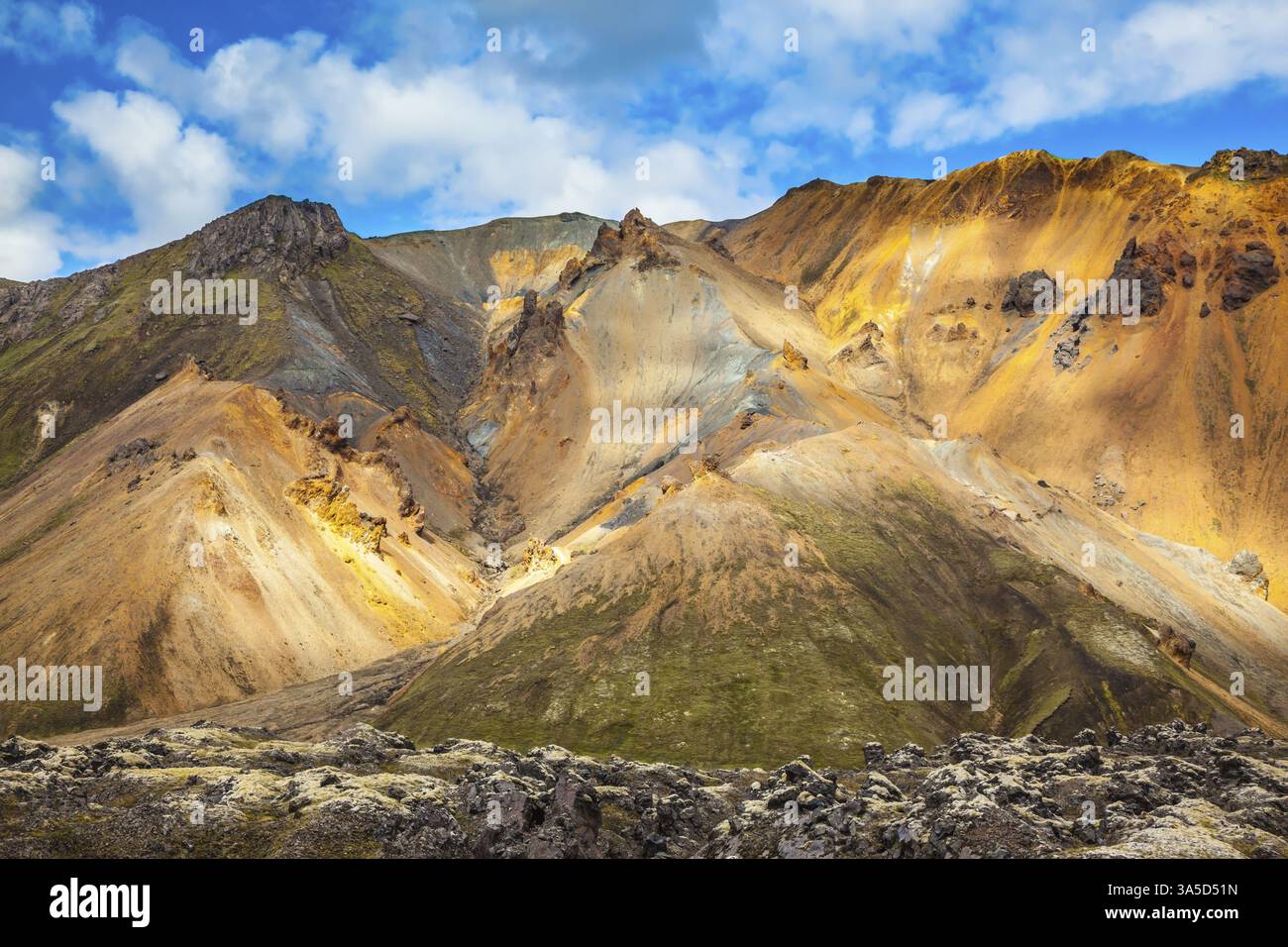 Le montagne multicolore della riolite sono illuminate dal sole di luglio. Viaggio in Islanda in estate. Parco nazionale Landmannalaugar Foto Stock