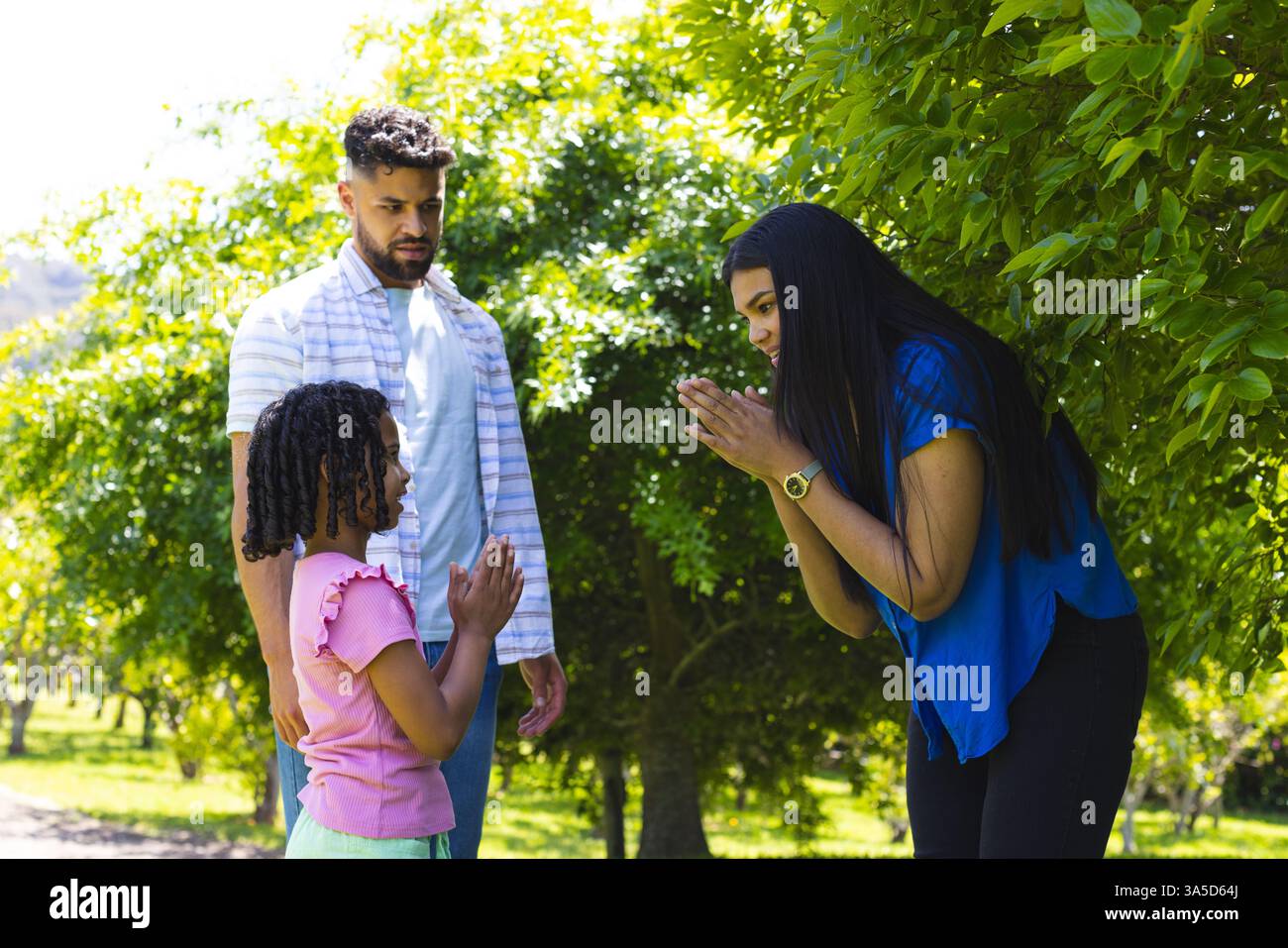 La famiglia si diverte all'aria aperta e mamma e figlia condividono momenti di gioco nel parco Foto Stock