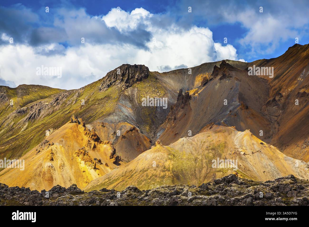 Le montagne riolite multicolore mettono in risalto il sole di luglio. Viaggio in Islanda in estate. Parco nazionale Landmannalaugar Foto Stock
