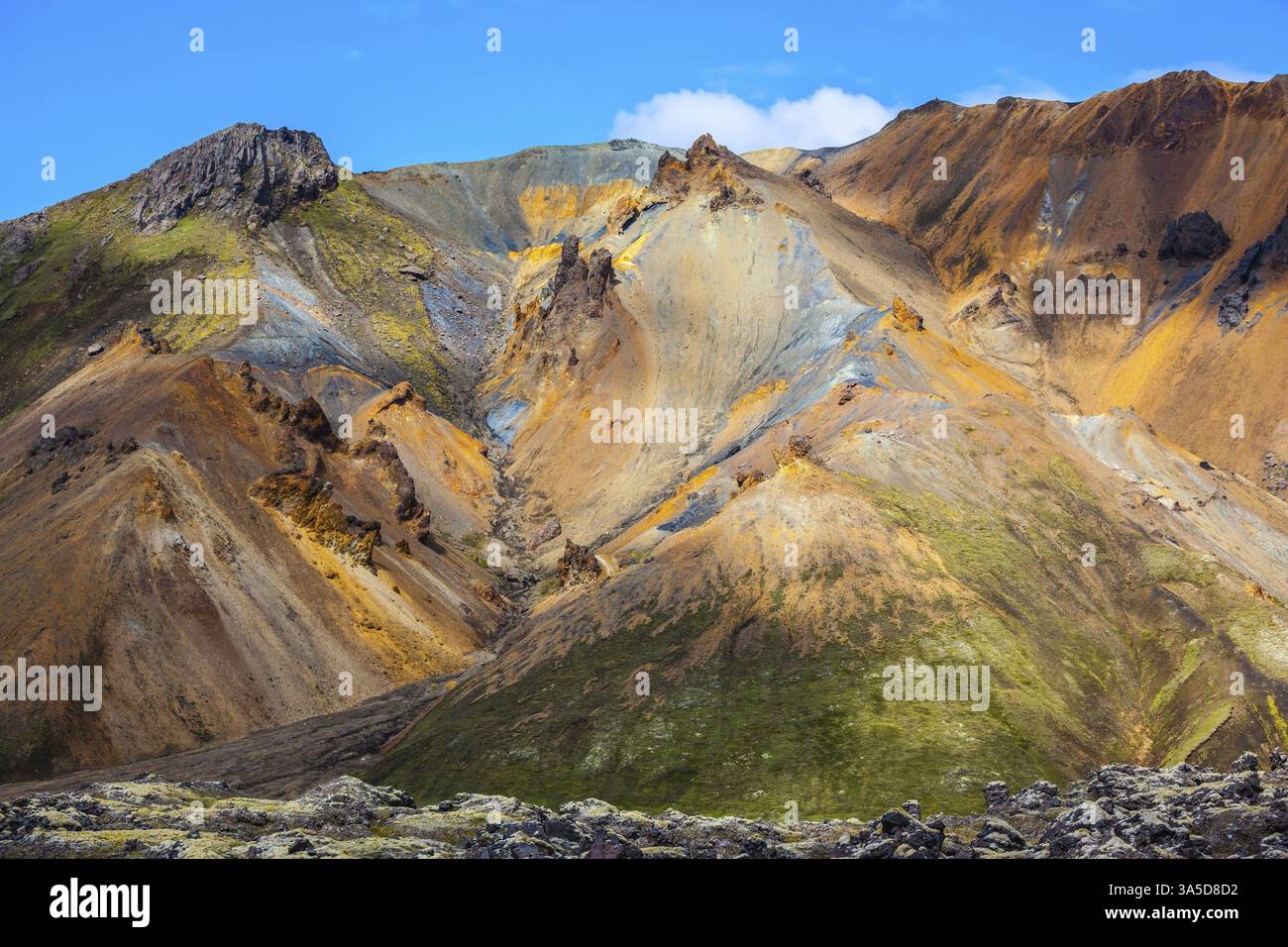 Viaggio in Islanda a luglio. Montagne multicolore di riolite minerale sono illuminate dal sole. Tundra vulcanica estiva Foto Stock