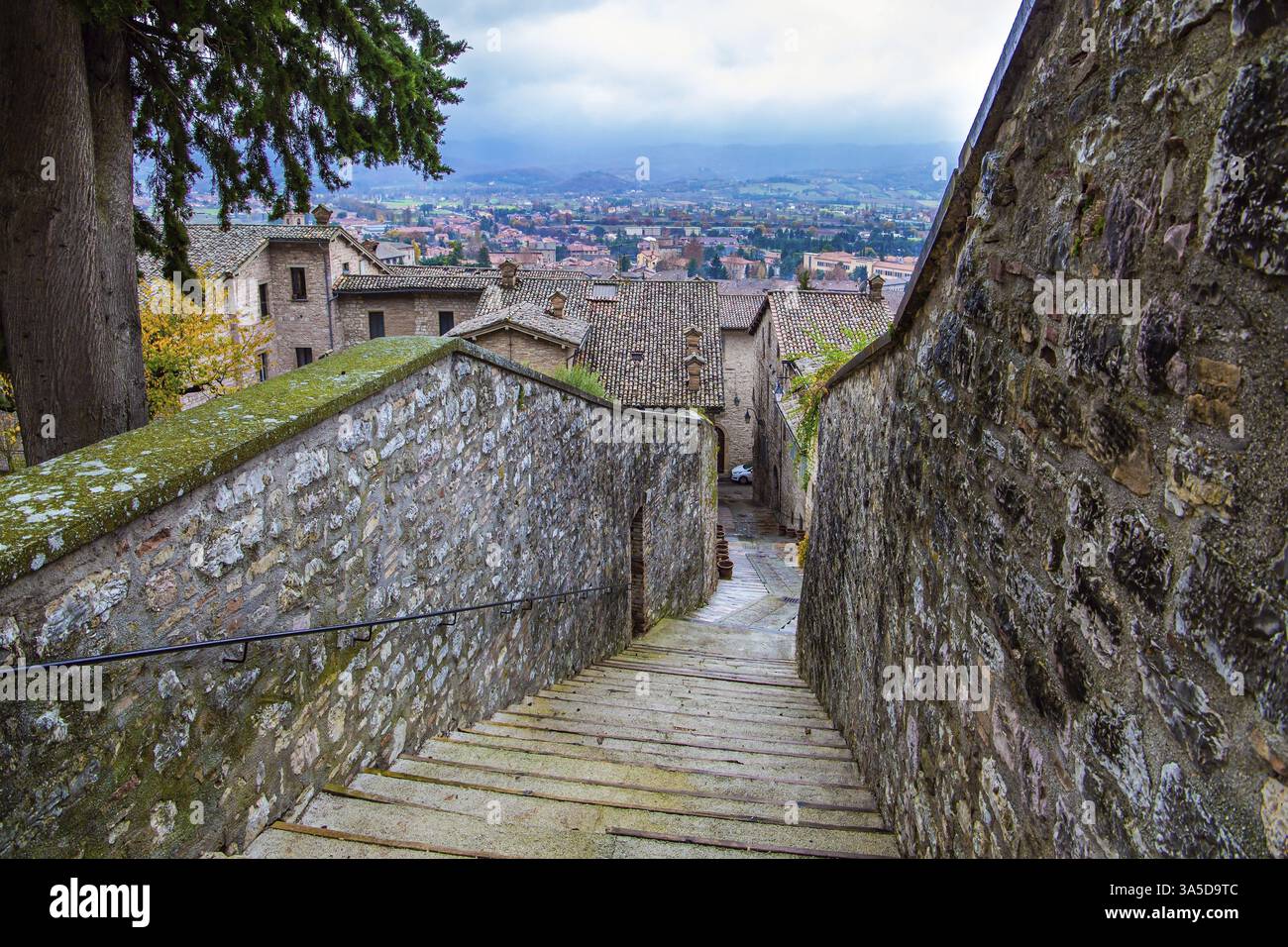 Uno stretto sentiero di ciottoli conduce alla cima della collina. Autunno nuvoloso giorno. Magnifica Italia. La città di Gubbio è situata tra le montagne umbre. R Foto Stock