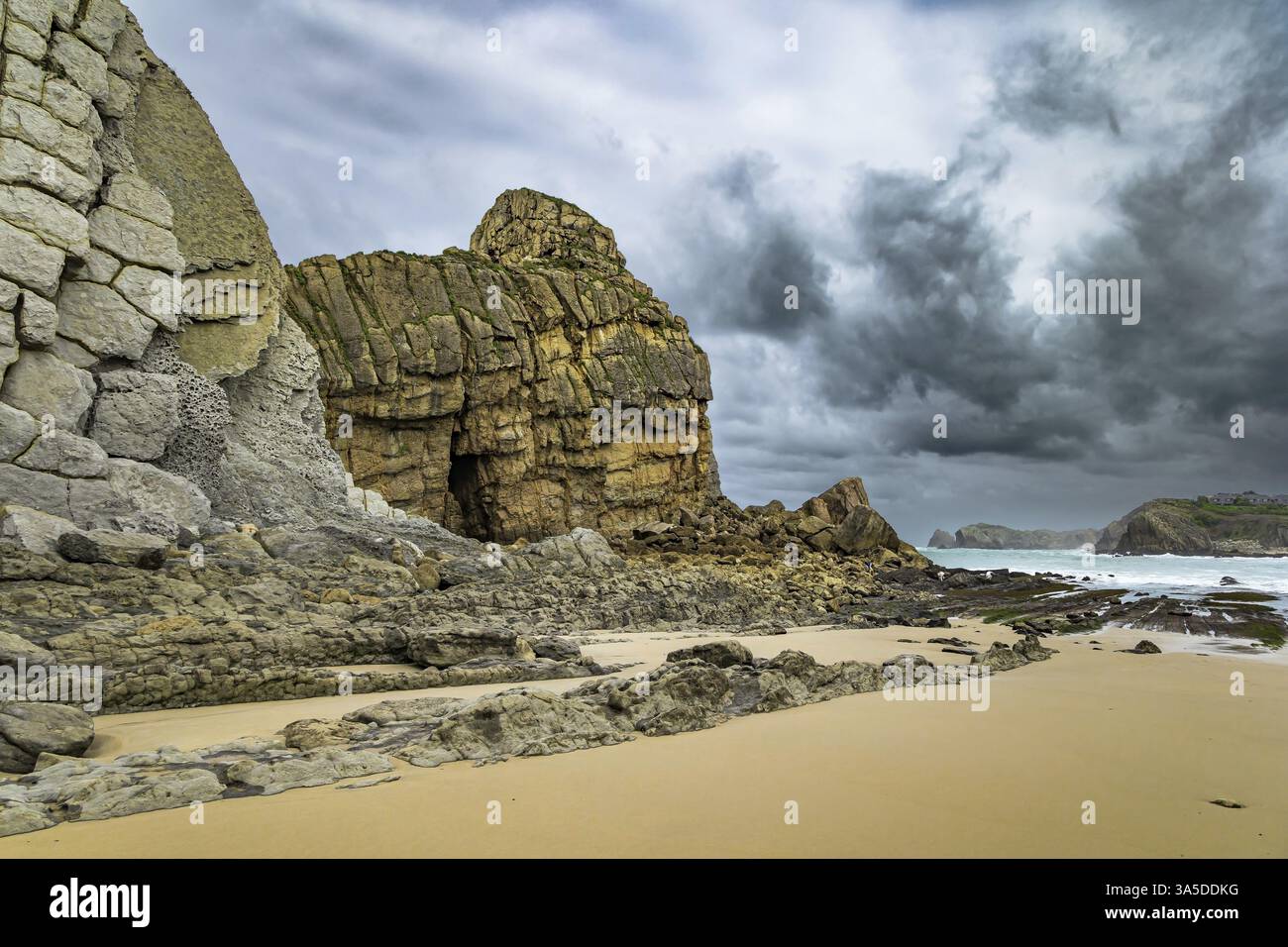 Onde da surf potenti con cresta in schiuma. Cantabria. Giornata ventosa e tempestosa sulla costa atlantica. Pittoresca costa oceanica rocciosa. Mezzogiorno sulla spiaggia di Playa di Foto Stock