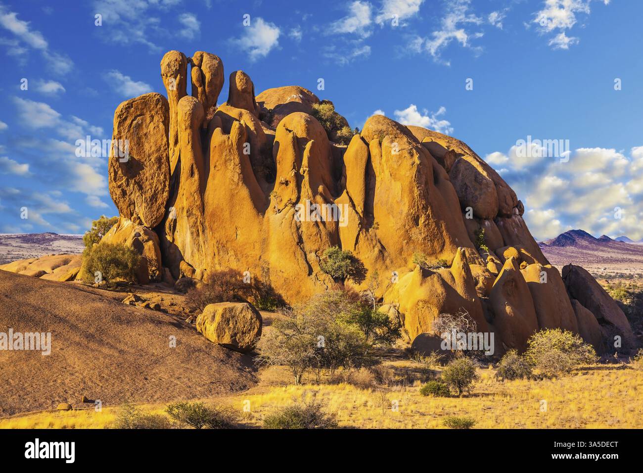 Riserva naturale Spitzkoppe. I pittoreschi archi in pietra dipinti in rosso e arancione. Il sole serale allunga le ombre tra le rocce Foto Stock