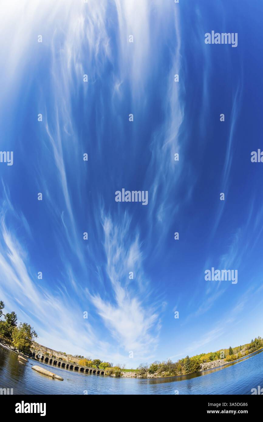 Le nuvole di Cirrus si riflettono nel fiume Winnipeg. Estate indiana a Manitoba, Old Pinawa Dam Park. Il concetto di turismo ecologico e ricreativo Foto Stock