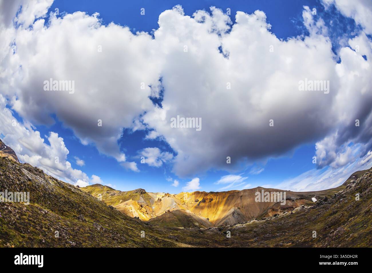 Montagne di riolite multicolore: Arancione, giallo, verde e blu. La foto è stata scattata con l'obiettivo Fisheye. Viaggio in Islanda a luglio, tumulo vulcanico estivo Foto Stock