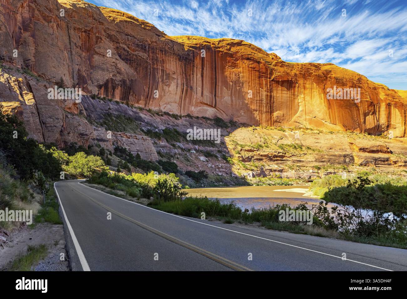 I grandiosi paesaggi d'America. Ampia strada asfaltata tra colline e rocce pittoresche. Utah Red Sandstones. Mattina presto, in un bel giorno d'autunno Foto Stock