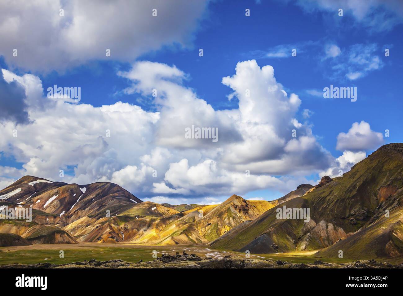 Le montagne multicolore di riolite minerale sono illuminate dal sole di luglio. Viaggio in Islanda in estate. Parco nazionale Landmannalaugar Foto Stock