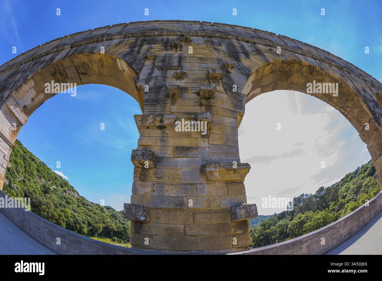 Parte del ponte. Una campata del ponte è rappresentata da un obiettivo fotografato Fisheye. Acquedotto a tre livelli Pont du Gard - il più alto d'Europa. Provenza, sole primaverile Foto Stock