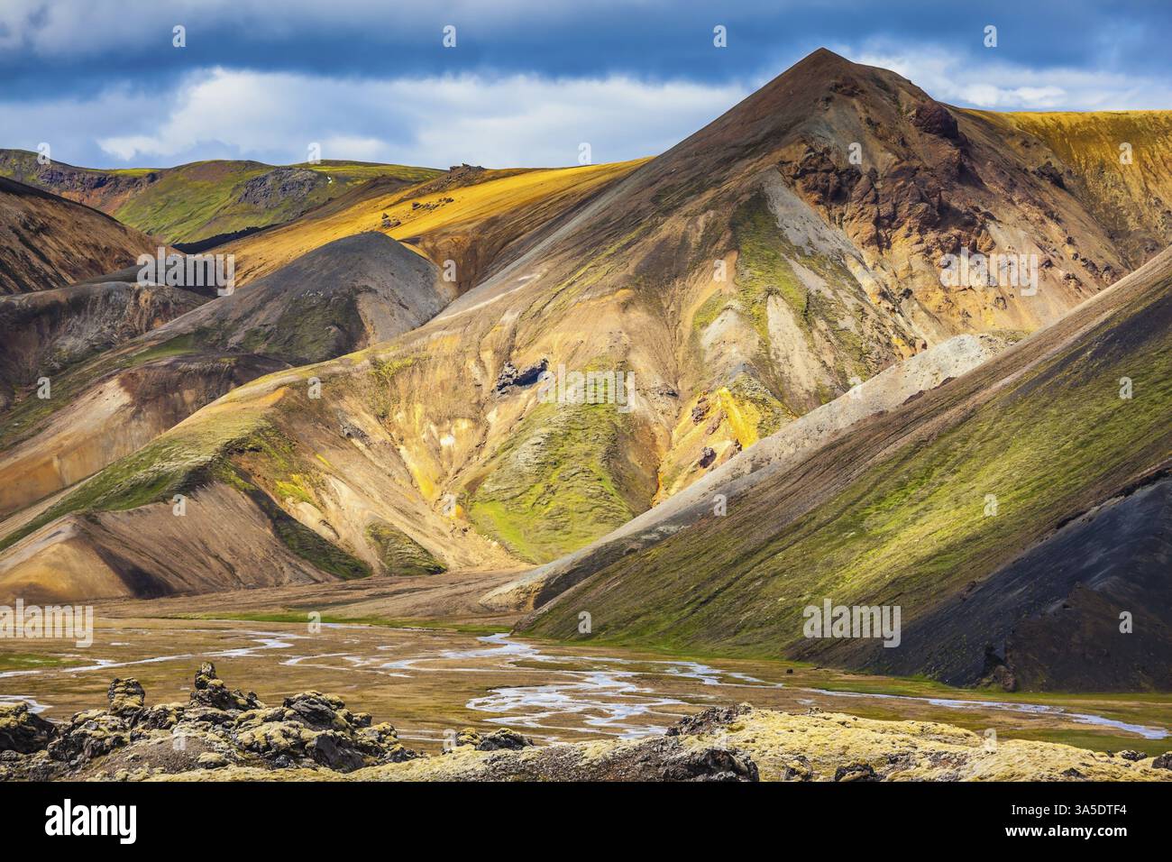 Viaggio in Islanda in estate. Parco nazionale Landmannalaugar. Le montagne multicolore di riolite minerale sono illuminate dal sole di luglio Foto Stock