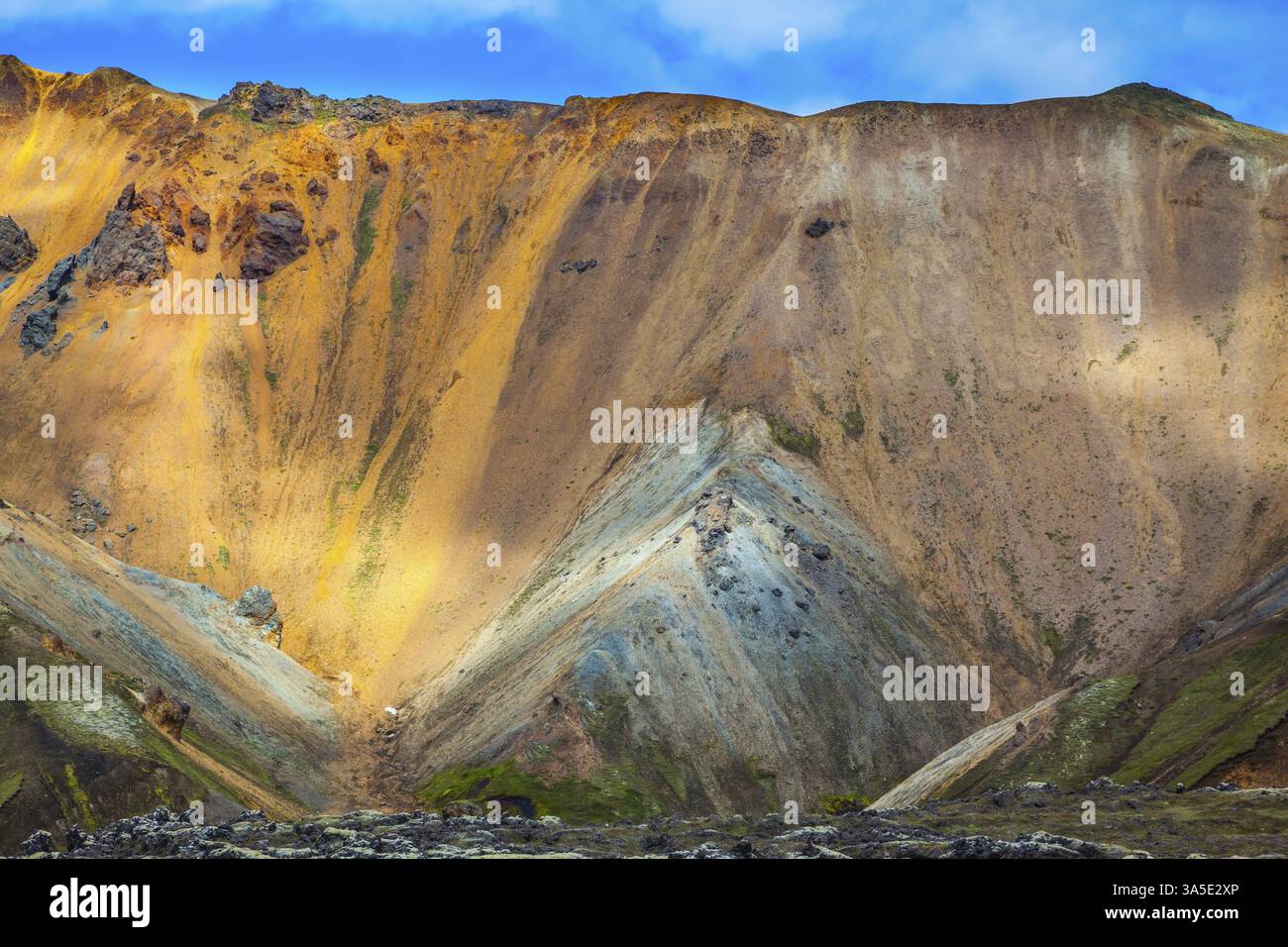 Le montagne multicolore di riolite minerale sono illuminate dal sole di luglio. Viaggio in Islanda in estate. Parco nazionale Landmannalaugar Foto Stock