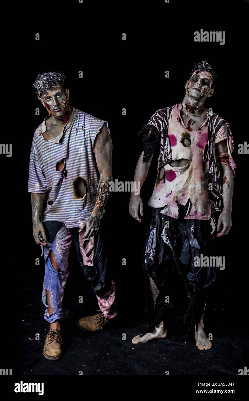 Due maschi zombie in piedi su sfondo nero a camminare verso la telecamera Foto Stock