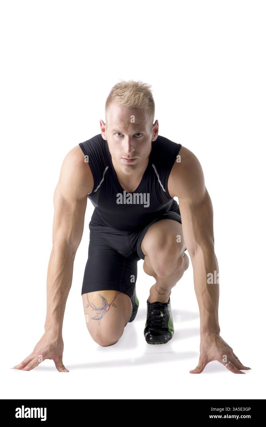 Foto di un maschio biondo con una camicia nera e pantaloncini corti in un ambiente da studio Foto Stock