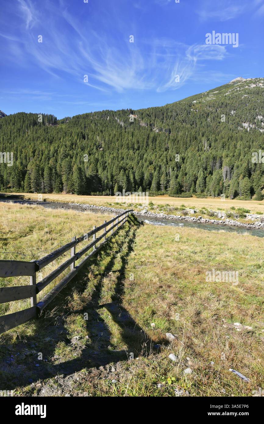 Campi panoramici bloccati accanto al recinto di legno. L'ombra della recinzione bassa giace splendidamente sull'erba. Valle alpina in Austria. Parco nazionale di Krimml wa Foto Stock