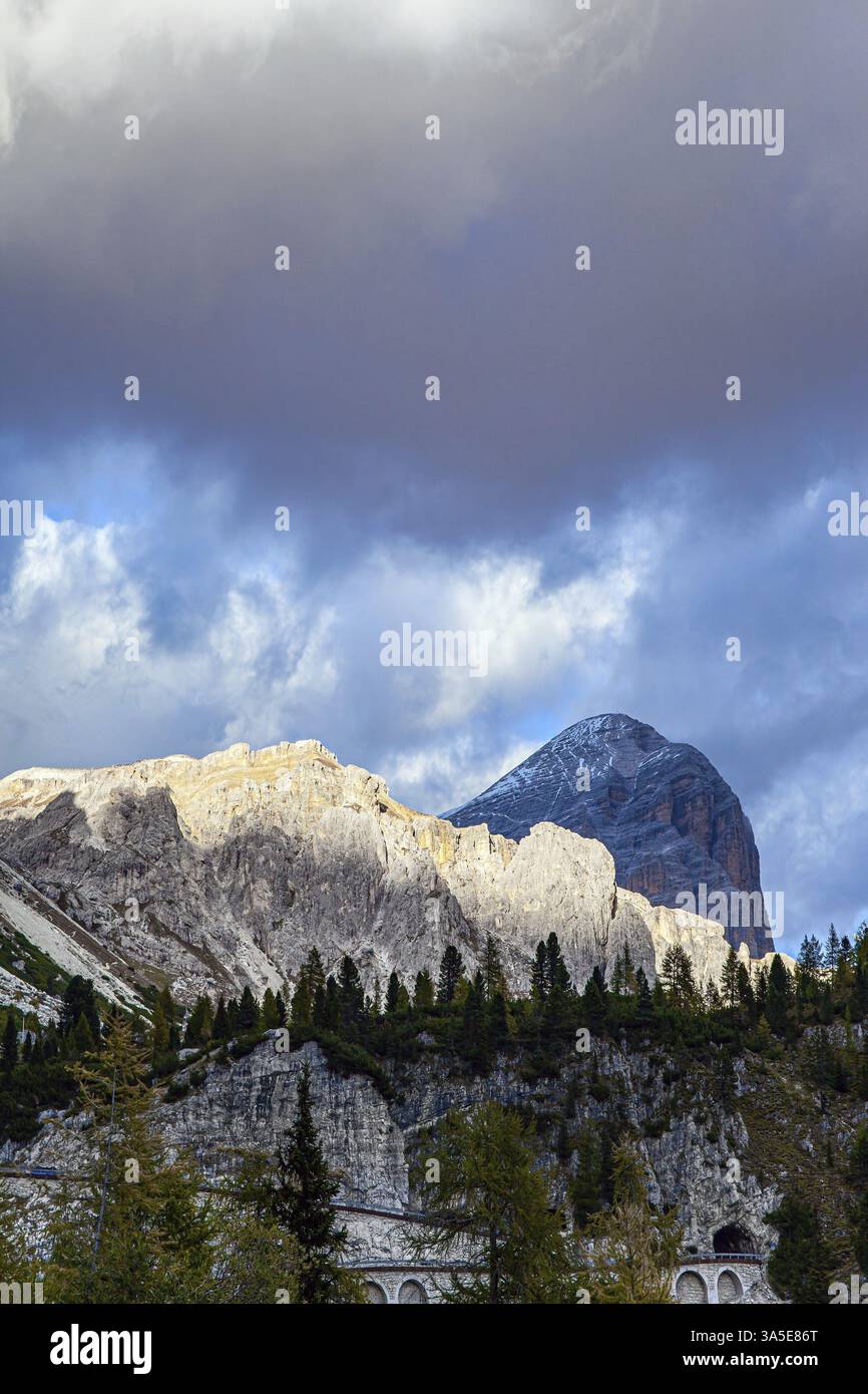 Il passo di Falzarego. Catena montuosa delle Alpi Orientali. Tramonto nelle rocce colorate delle Dolomiti. I pini e le spruces sottili crescono ai piedi di t Foto Stock