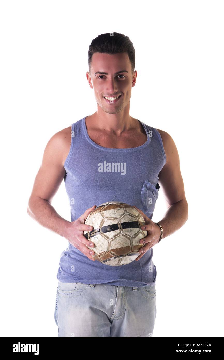 Sorridente giovane tanktop tenendo palla calcio, guardando la telecamera, isolato su bianco Foto Stock