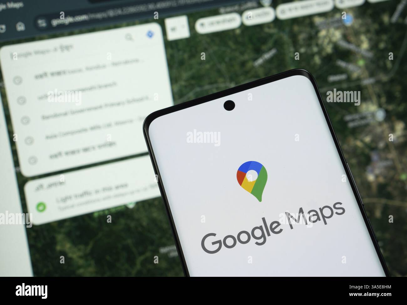 Il logo di google Maps viene visualizzato sullo schermo di uno smartphone e il sito Web google Maps è visibile sullo schermo di un computer sullo sfondo Foto Stock