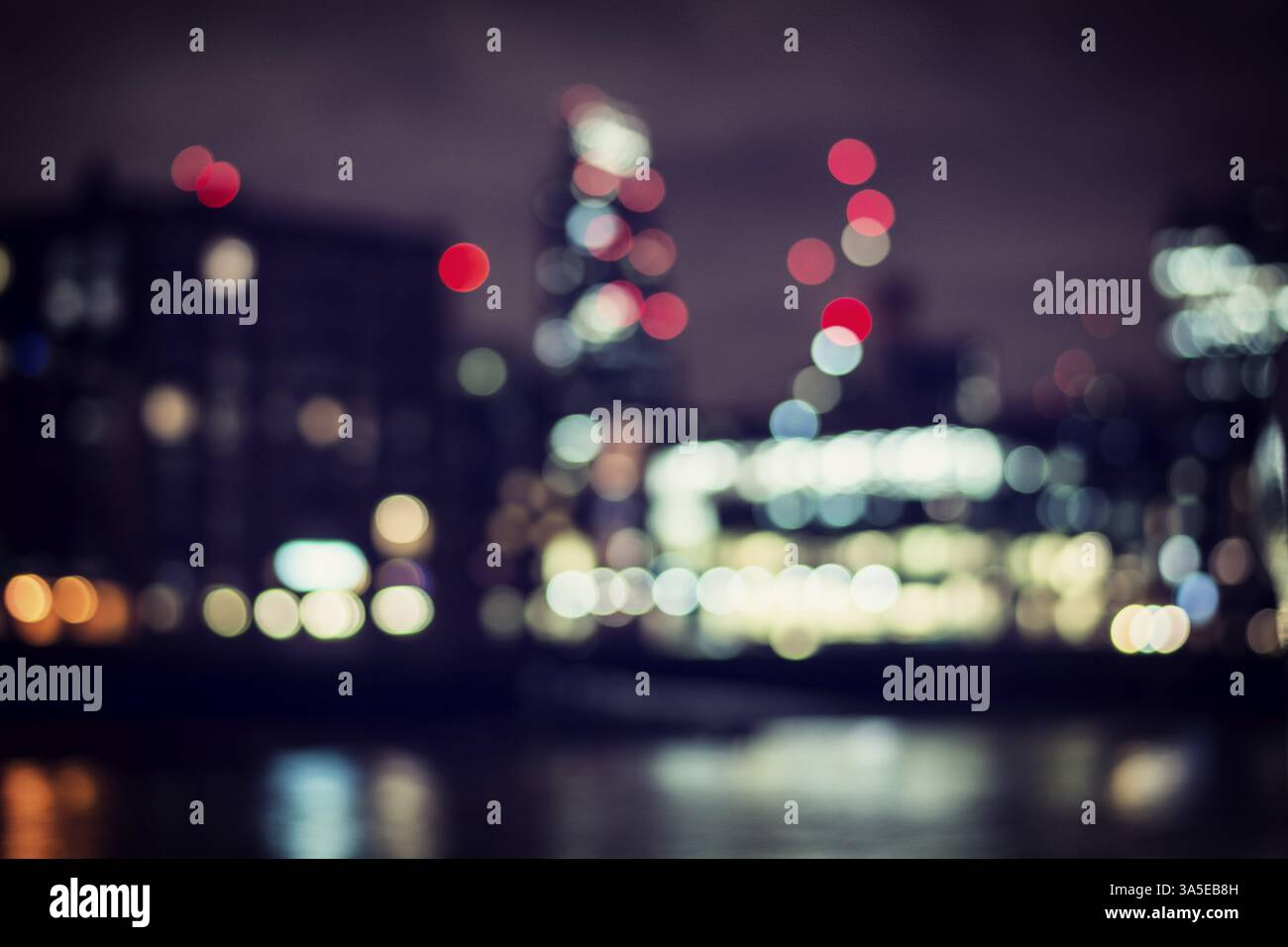 Foto all'aperto orizzontale delle luci bokeh in una città sul fiume o sul mare, di notte Foto Stock